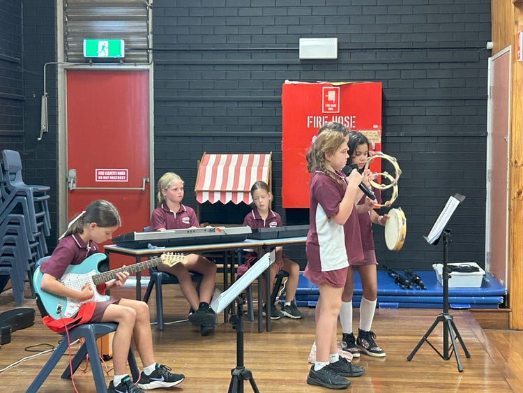 Five students playing musical instruments together.