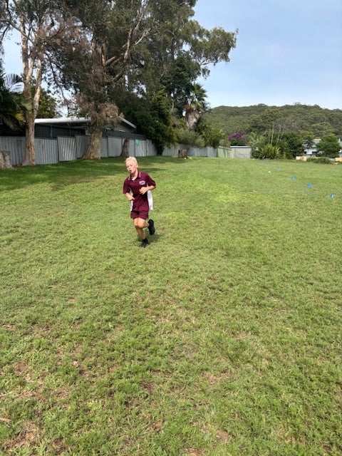 A young student running on s aports field.